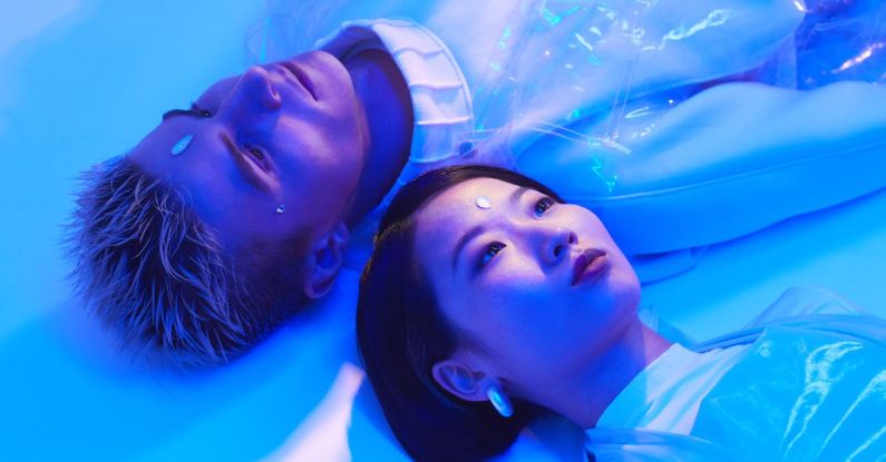 Automation Insights - Futuristic Photo of a Young Man and Woman Lying on the Floor in Blue Lighting