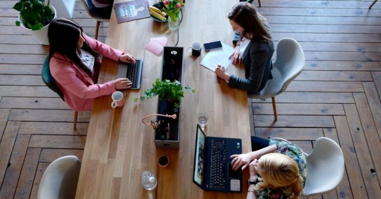 Workplace - Three Woman Sitting on White Chair in Front of Table