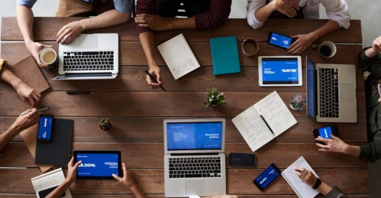 Workplace - Top View Photo Of People Near Wooden Table