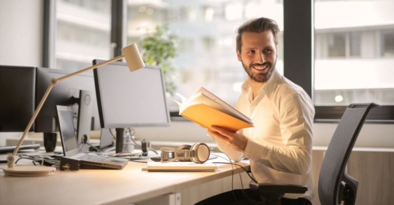 Workplace - Photo of Man Holding a Book