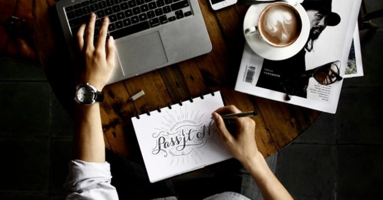 Business - Person Sitting Facing Laptop Computer With Sketch Pad